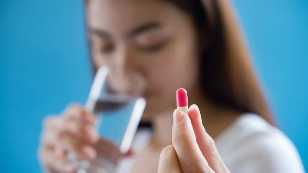 Janeiro Branco e Menopausa: um olhar integrativo para a saúde mental da mulher mulher bebendo agua segurando ansiolitico