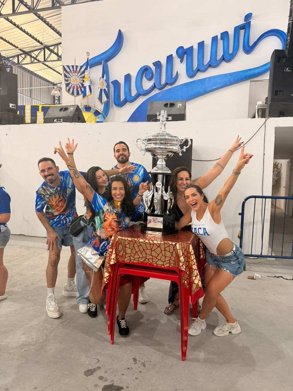 Rainha de bateria Carla Prata comemora campeonato do Tucuruvi com troféu na quadra 18 Carla Prata ladeada de sua equipe - Crédito da Foto: Renato Cipriano - Divulgação